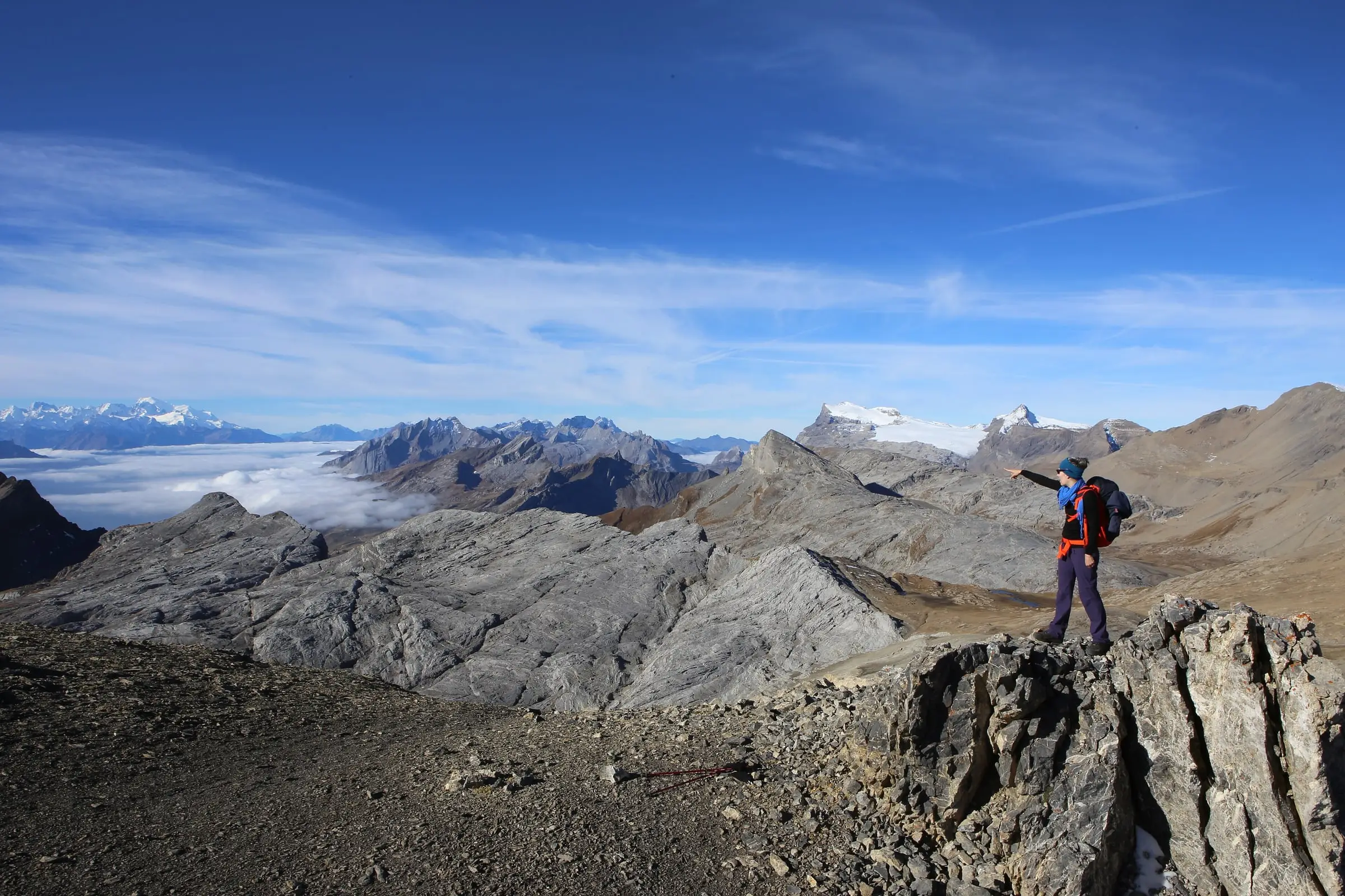 Hiker gazing towards Mont Blanc above a sea of clouds